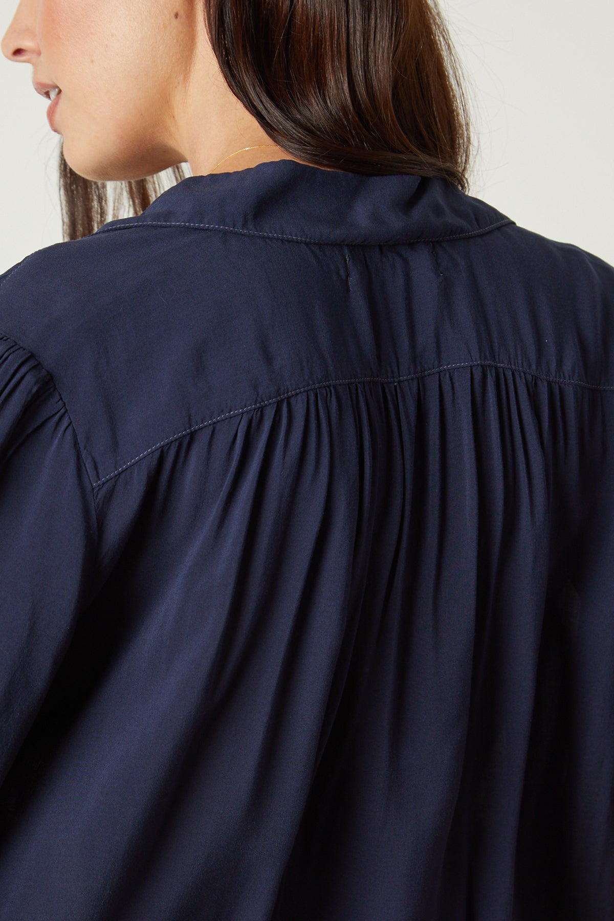 The back view of a woman wearing a Velvet by Graham & Spencer Nikki Button-Up Top in navy.-26496273219777