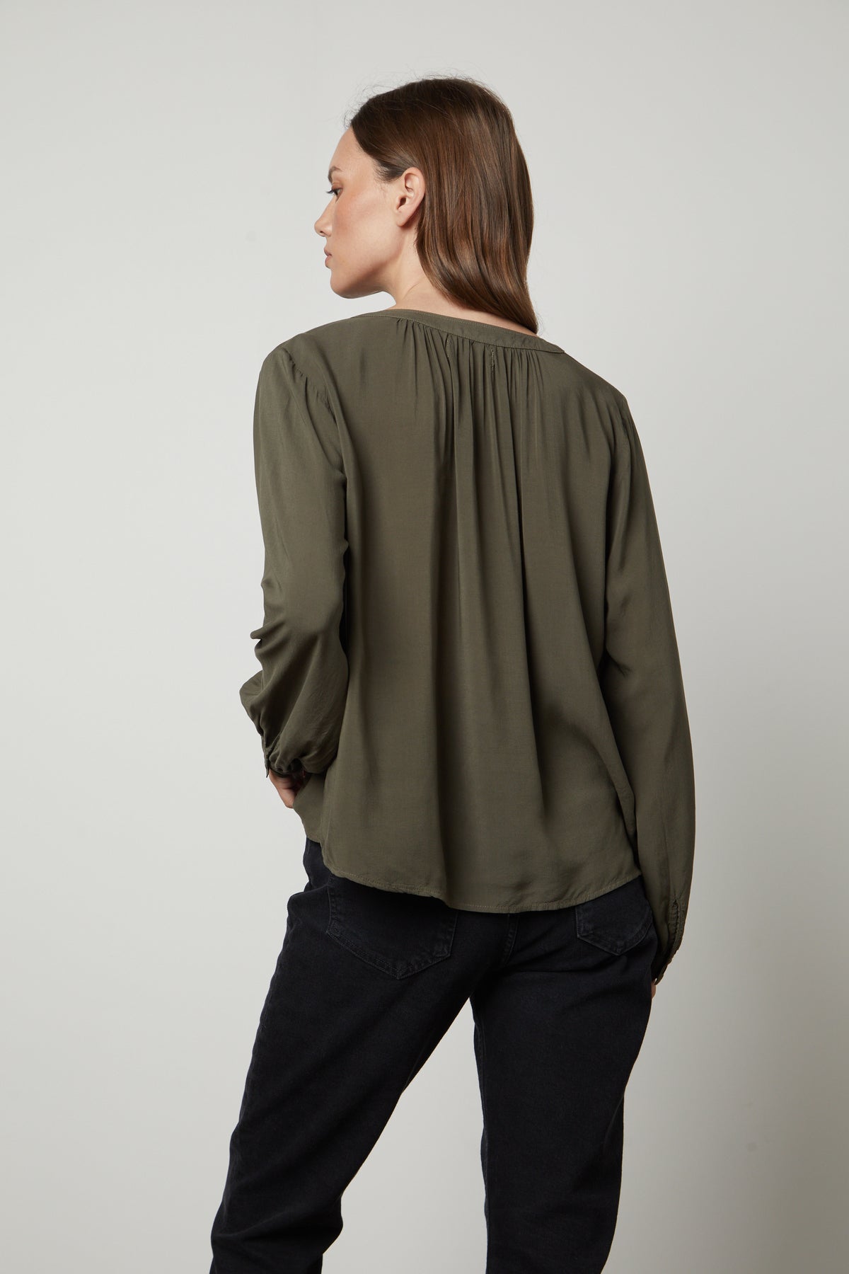  The back view of a woman wearing jeans and a Velvet by Graham & Spencer POSIE SPLIT NECK BLOUSE. 