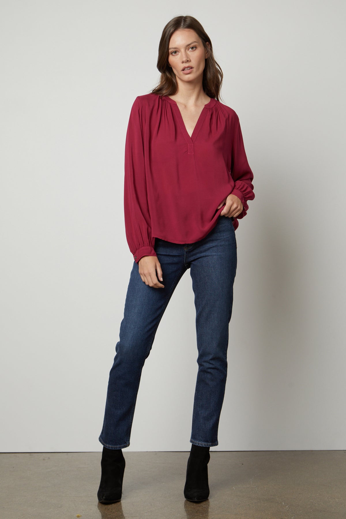 The model is wearing jeans and a Velvet by Graham & Spencer POSIE SPLIT NECK BLOUSE.-26861471203521