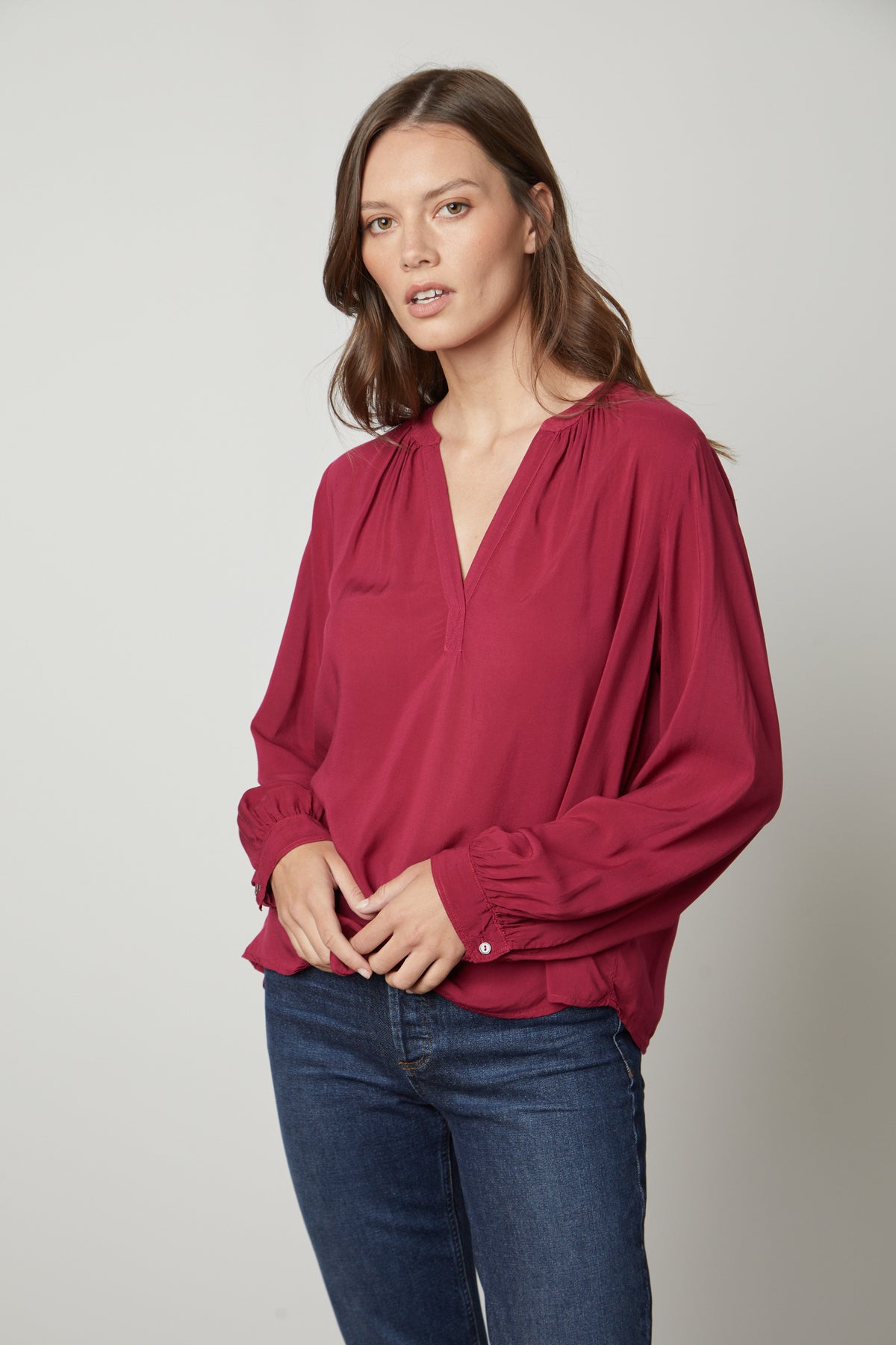A model wearing a Velvet by Graham & Spencer POSIE SPLIT NECK BLOUSE and jeans.-26861471137985