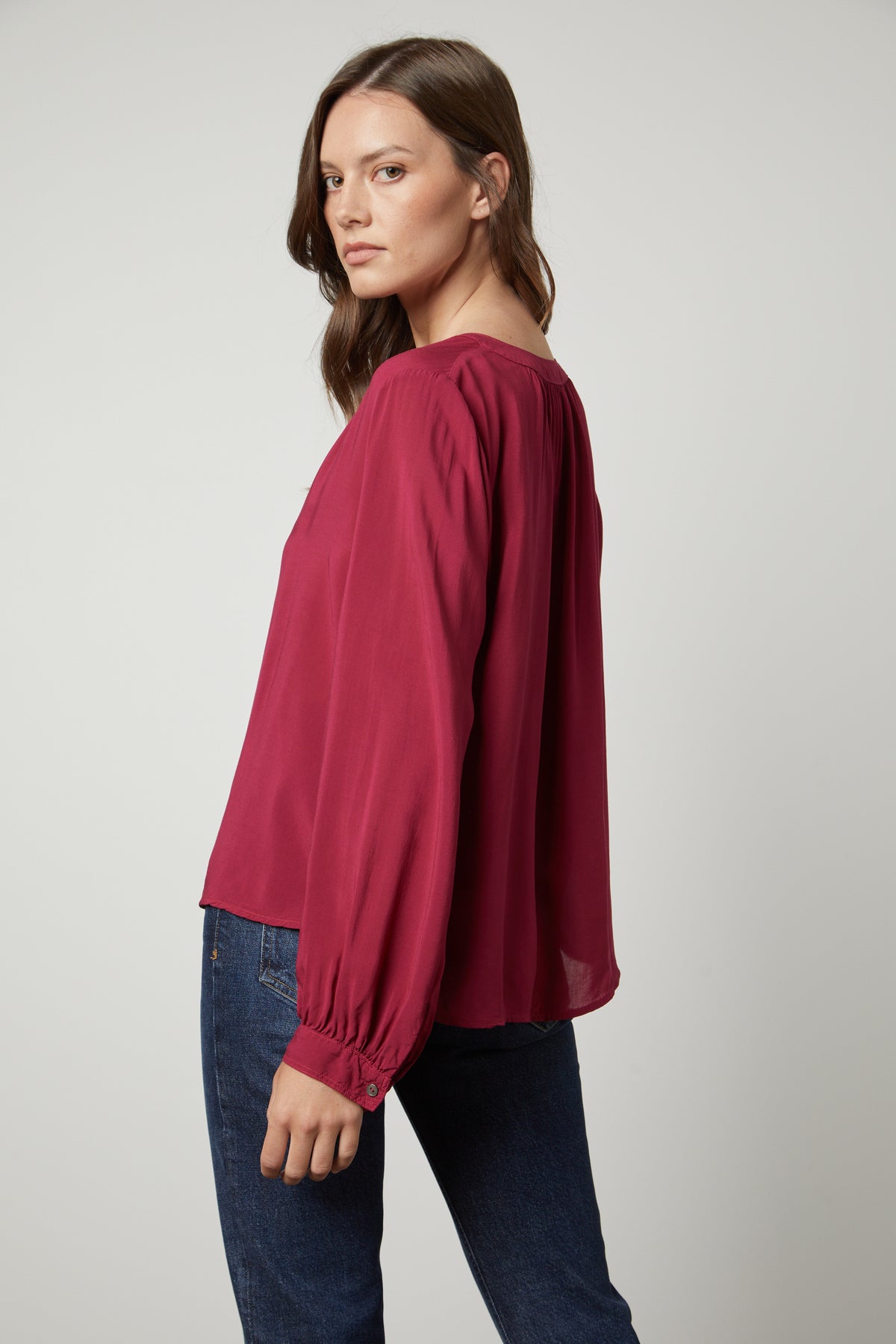 The back view of a woman wearing a Velvet by Graham & Spencer POSIE SPLIT NECK BLOUSE and jeans.-26861471170753