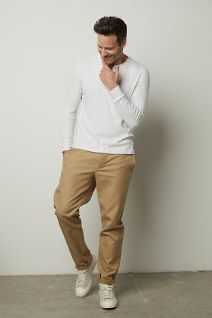 A man in an Anderson Rib Knit Henley by Velvet by Graham & Spencer and khaki pants.