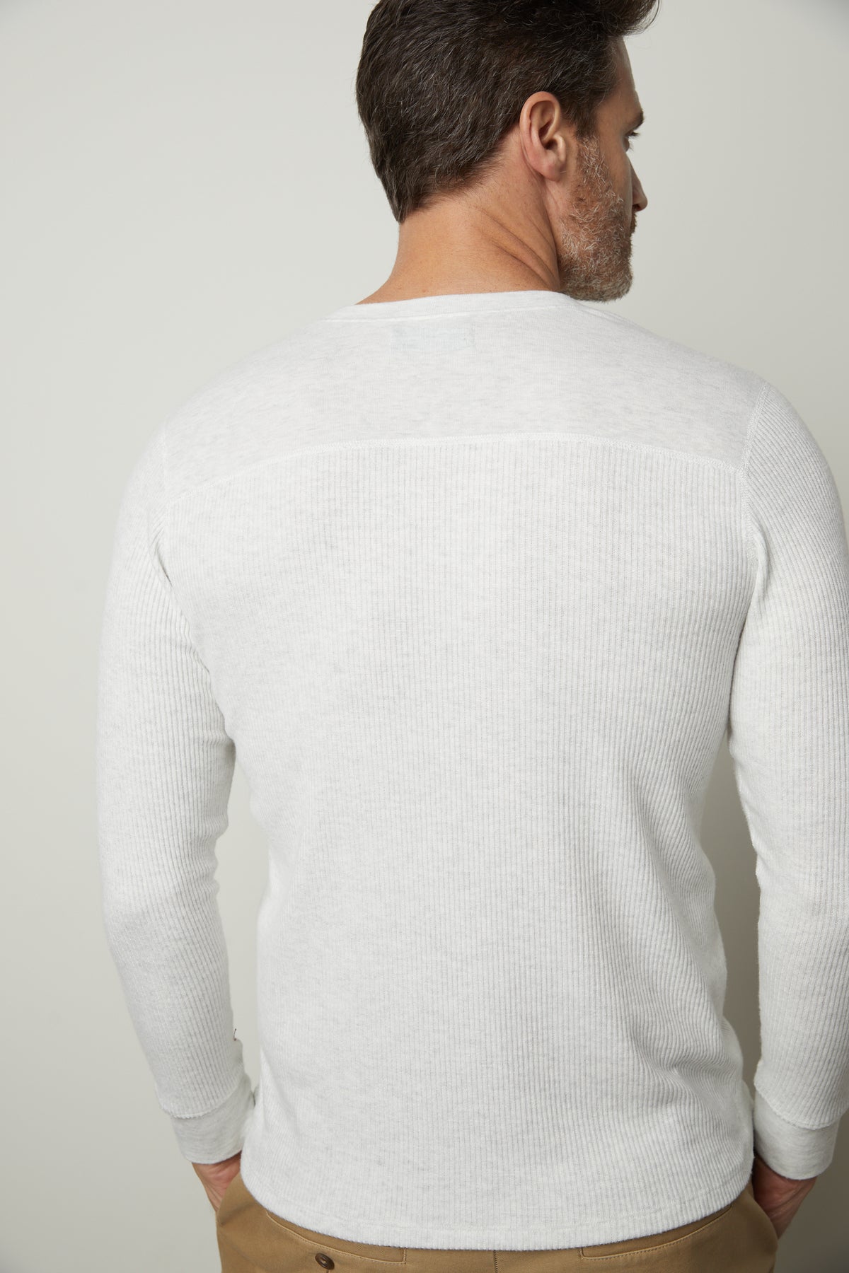 The back view of a man wearing a Velvet by Graham & Spencer Anderson Rib Knit Henley sweater.-35678467326145