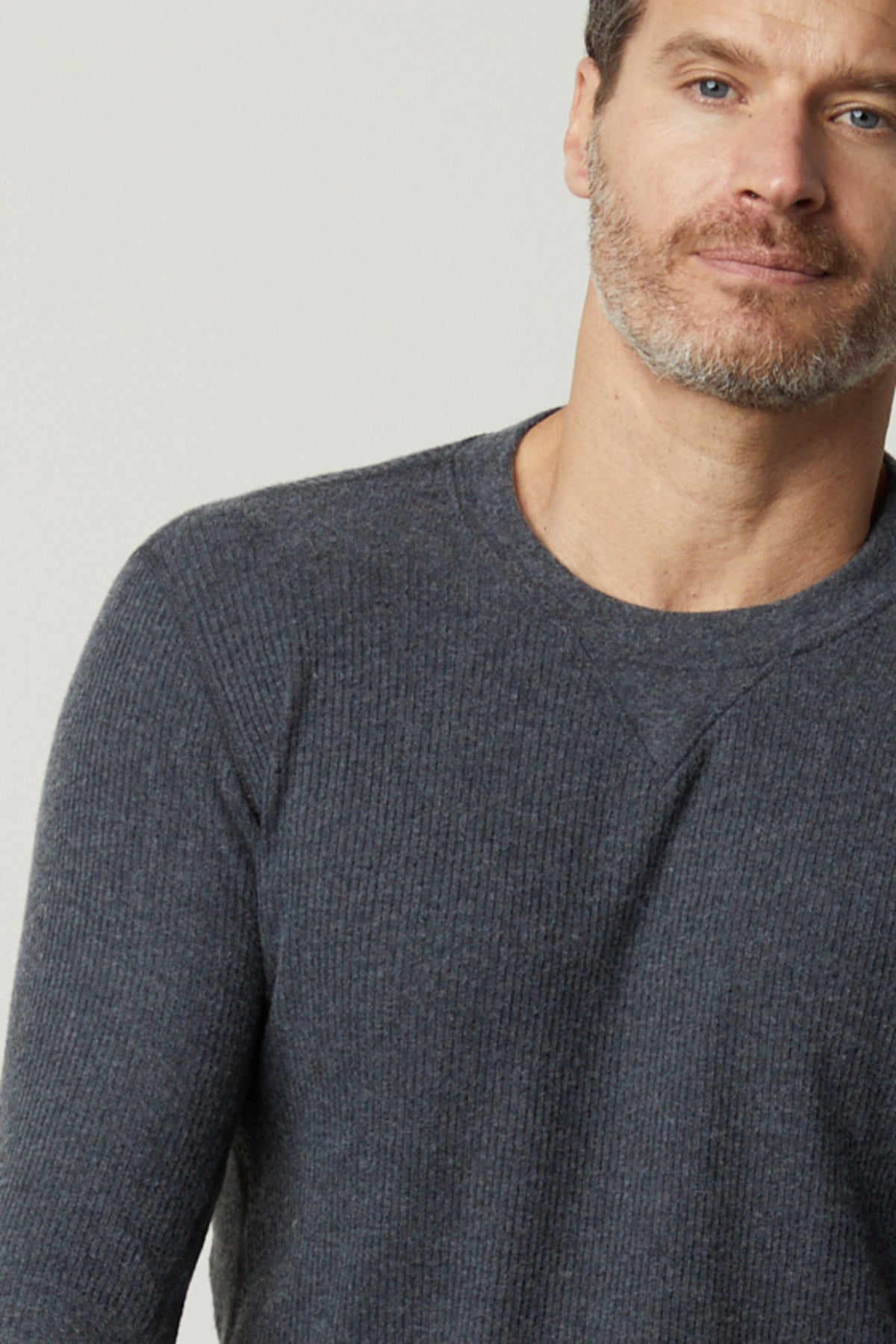 A man in a grey Velvet by Graham & Spencer sweater, the AUGUSTUS RIB KNIT CREW, is posing for a photo.-26905806766273