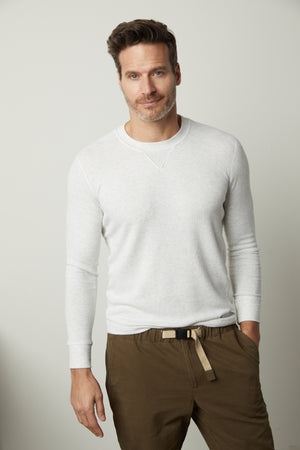 A man wearing a Velvet by Graham & Spencer AUGUSTUS RIB KNIT CREW sweater and khaki pants.