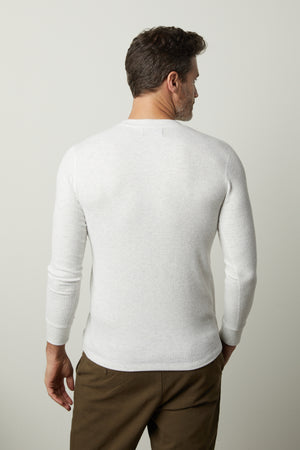 The back view of a man wearing a Velvet by Graham & Spencer AUGUSTUS RIB KNIT CREW white long - sleeved shirt.