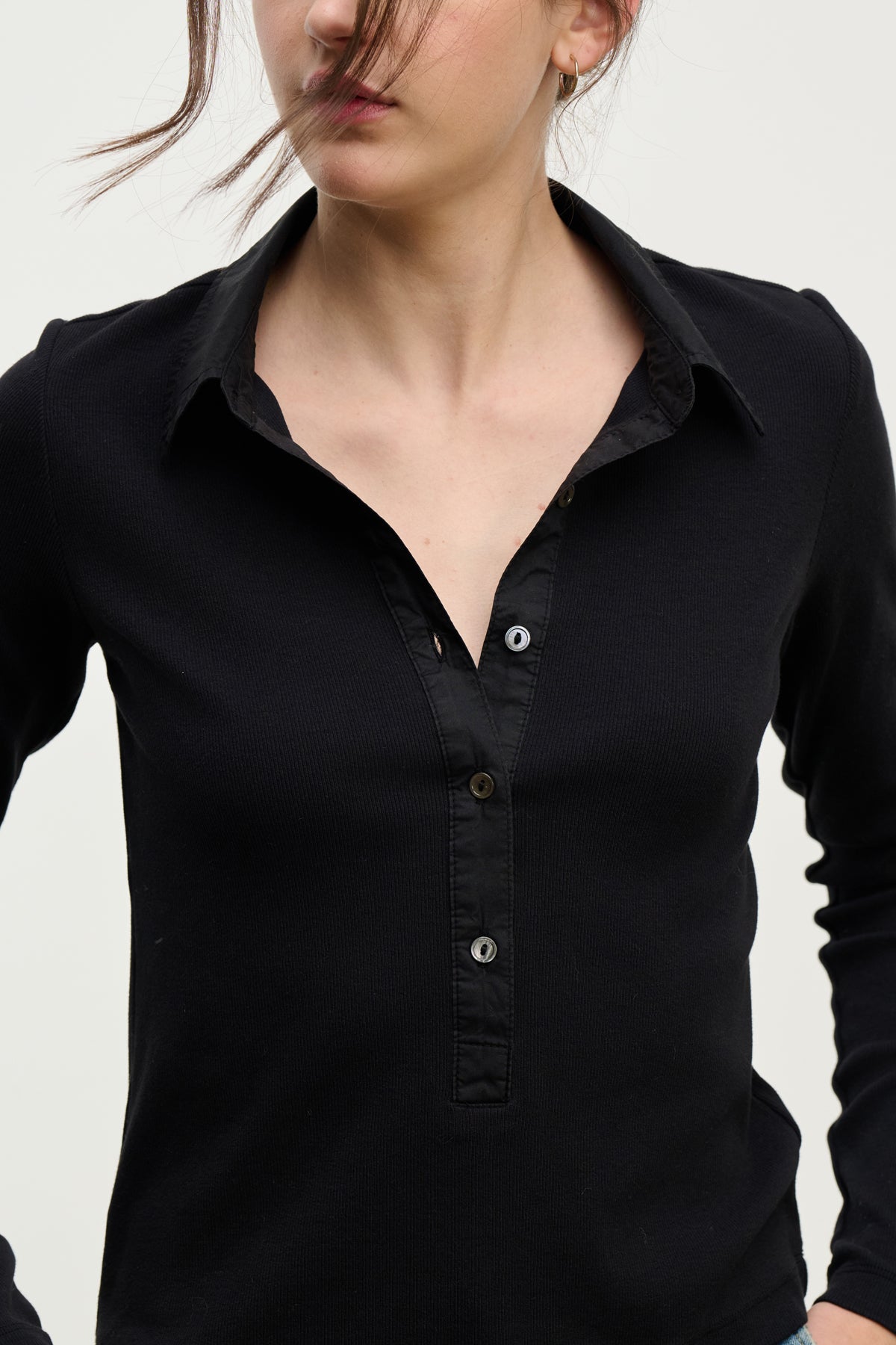 A person wears the ARVINE SHIRT by Velvet by Graham & Spencer, featuring a black ribbed design and cotton poplin collar, standing against a plain light background with their face partly hidden by hair.-Hover Image