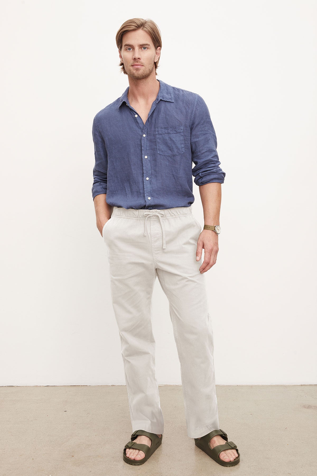 A man in a casual blue shirt and Velvet by Graham & Spencer BRANSON PANT, standing against a plain background.-36329591111873