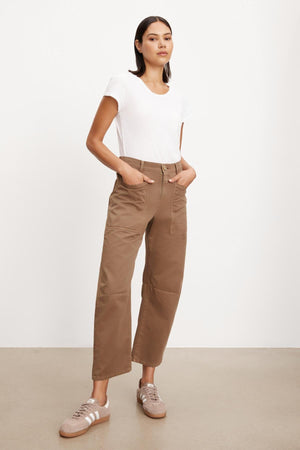 The model is wearing a white t-shirt and Velvet by Graham & Spencer brown cropped pants with patch pockets.