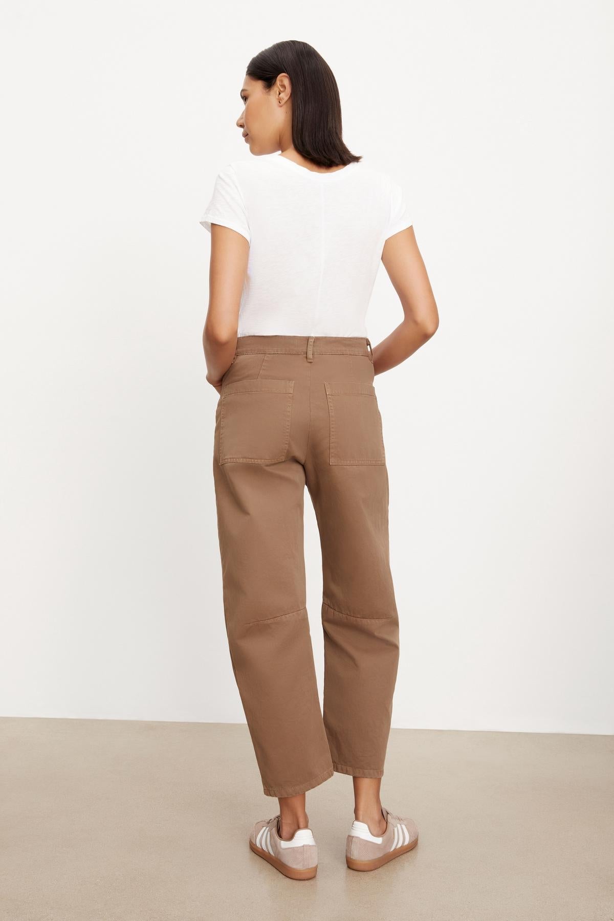   The back view of a woman wearing Velvet by Graham & Spencer's BRYLIE SANDED TWILL UTILITY PANT with curved silhouette. 