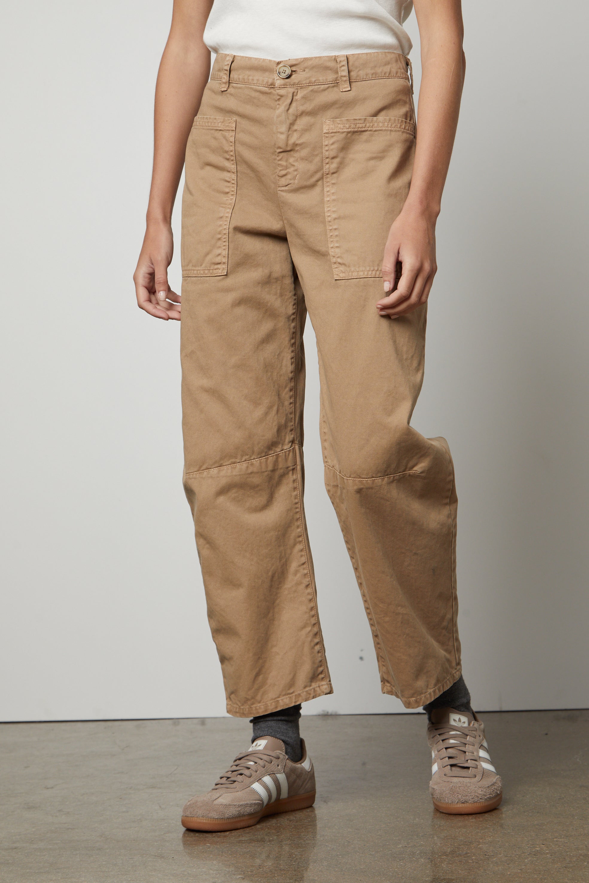   A woman wearing the Velvet by Graham & Spencer BRYLIE SANDED TWILL UTILITY PANT and white t-shirt. 