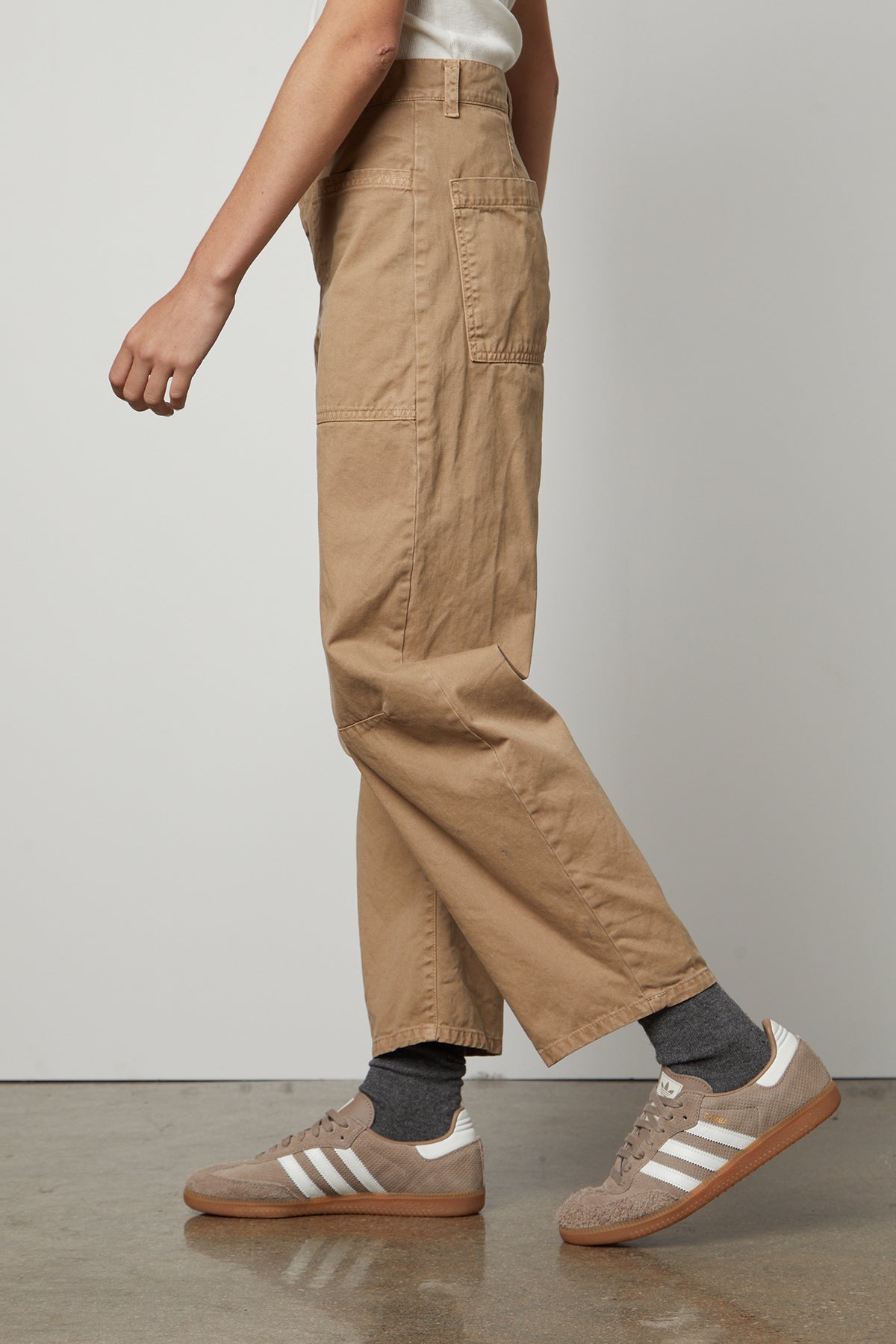 A man wearing Velvet by Graham & Spencer's BRYLIE SANDED TWILL UTILITY PANT and white sneakers.-36118556049601