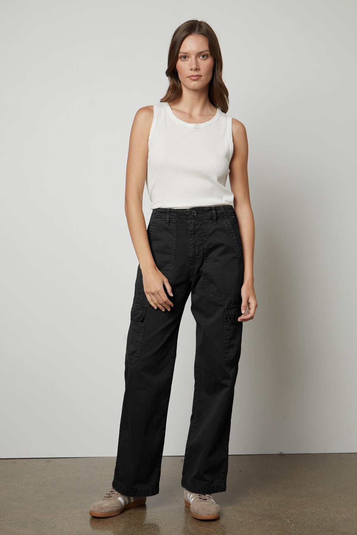 A woman wearing the Velvet by Graham & Spencer MAKAYLA SANDED TWILL CARGO PANT and a white tank top.-26914867708097