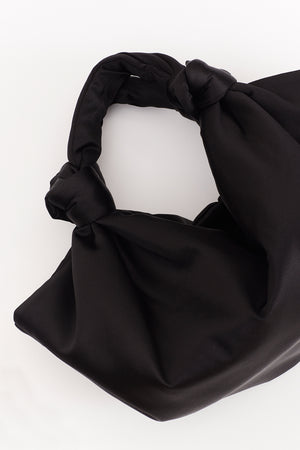 A ROBYN BAG by Velvet by Jenny Graham, a luxury handbag made of black satin with a knot on it.