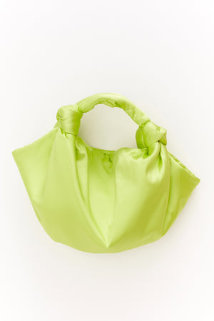 A ROBYN BAG by Velvet by Jenny Graham, a luxury lime green handbag on a satin surface.