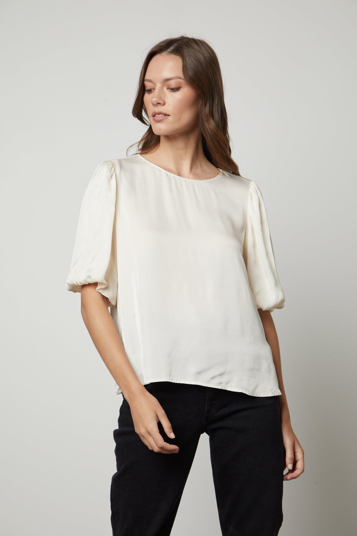 The model is wearing a Velvet by Graham & Spencer DESI SATIN PUFF SLEEVE TOP cream top.-35656169652417