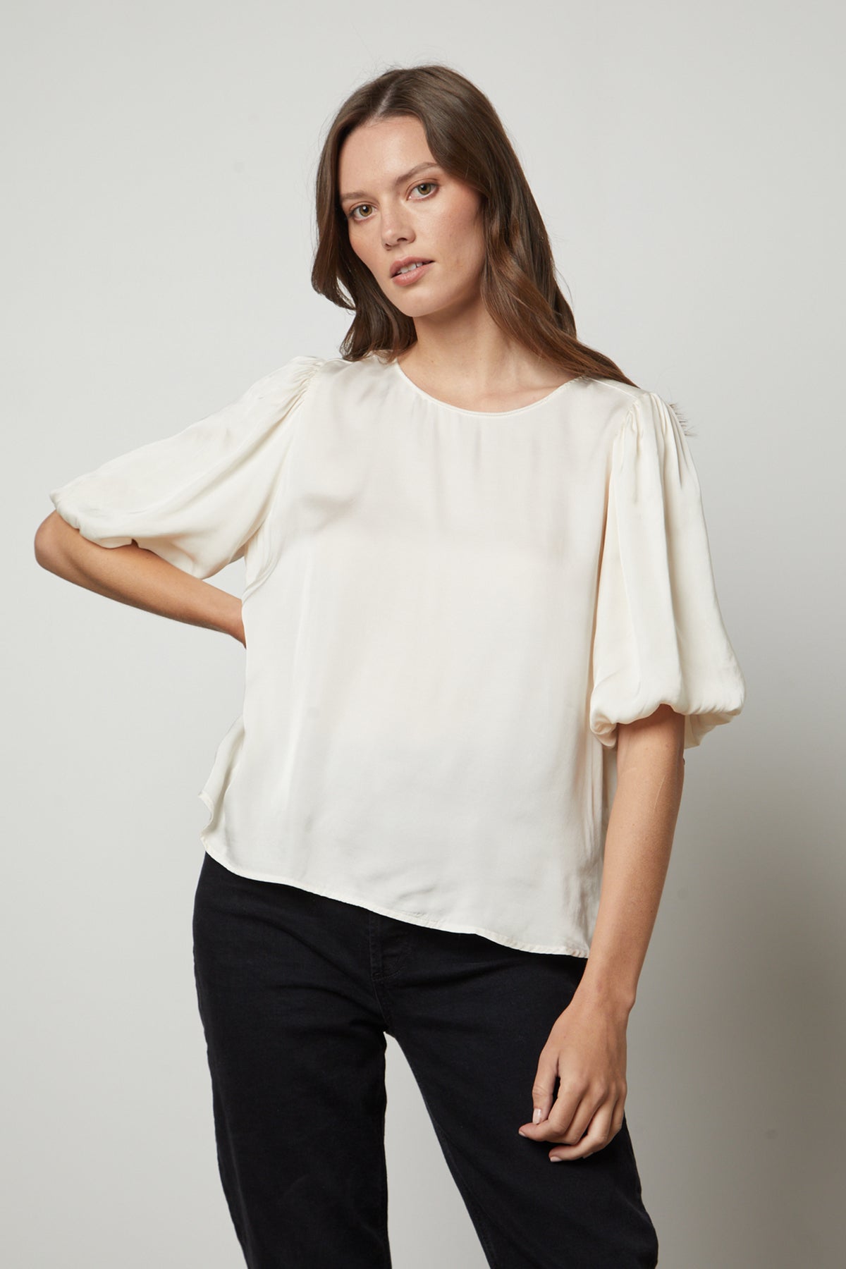 The model is wearing a DESI SATIN PUFF SLEEVE TOP by Velvet by Graham & Spencer.-35656169554113