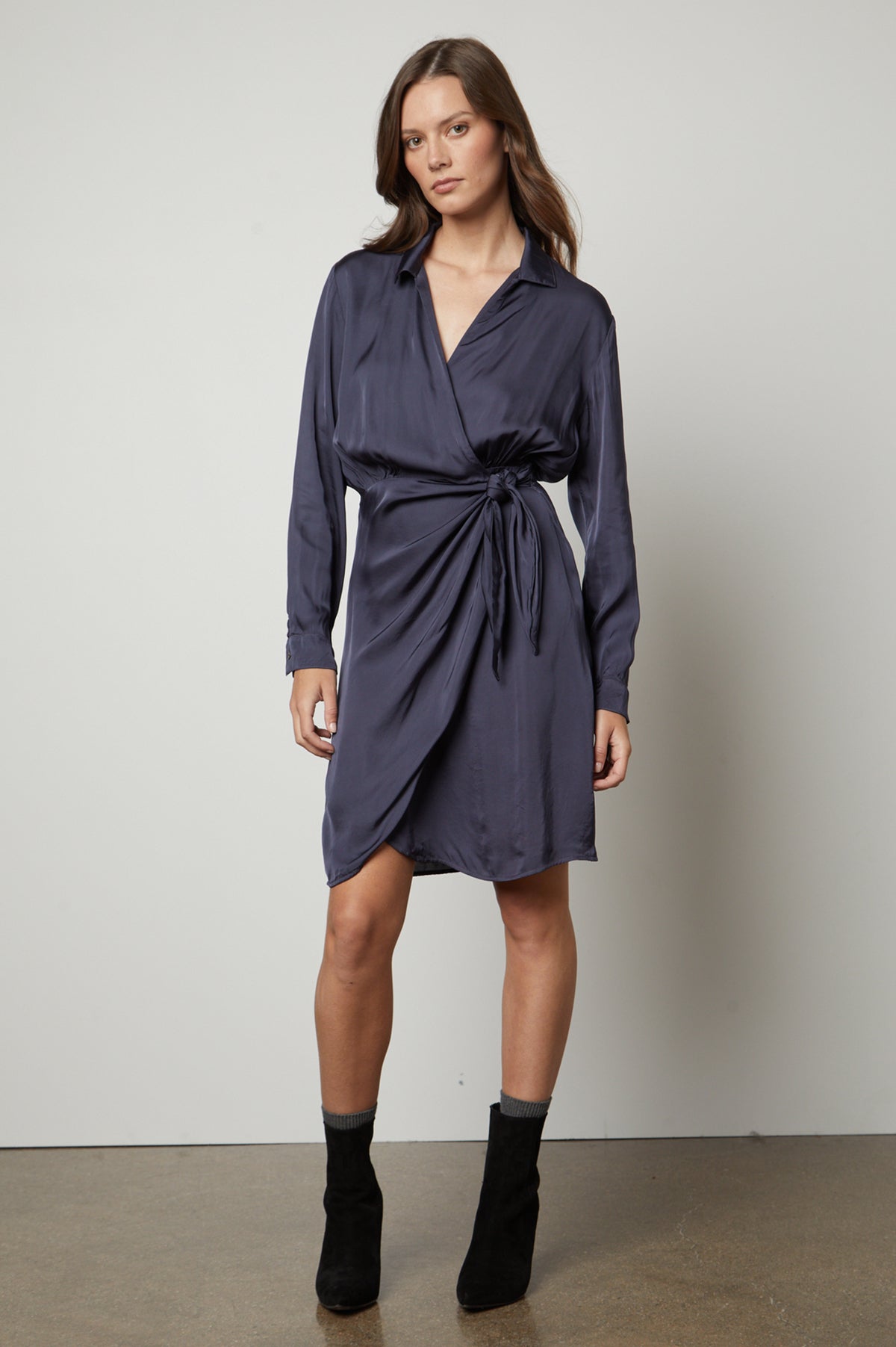 The model is wearing a dark blue Velvet by Graham & Spencer JUNI WRAP DRESS.-35656155332801