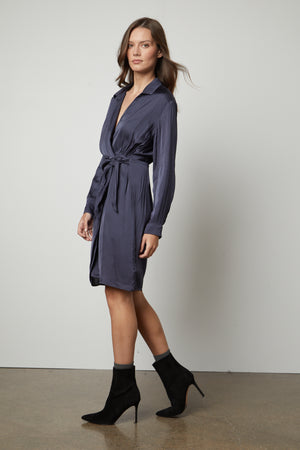The model is wearing a JUNI wrap dress by Velvet by Graham & Spencer with a v-neckline.