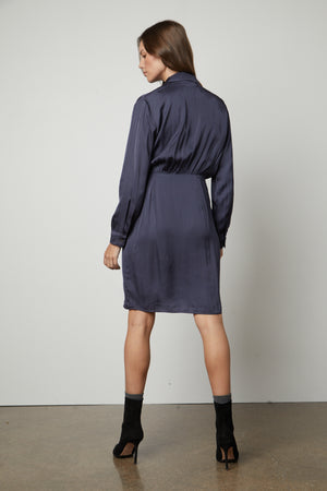 The back view of a woman wearing the Velvet by Graham & Spencer JUNI WRAP DRESS with v-neckline.