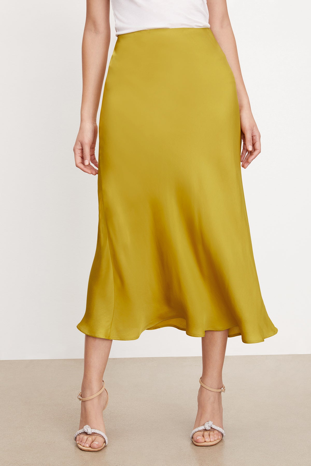 A silhouette of a woman wearing the Velvet by Graham & Spencer Aubree Satin Midi Skirt.-35577742065857