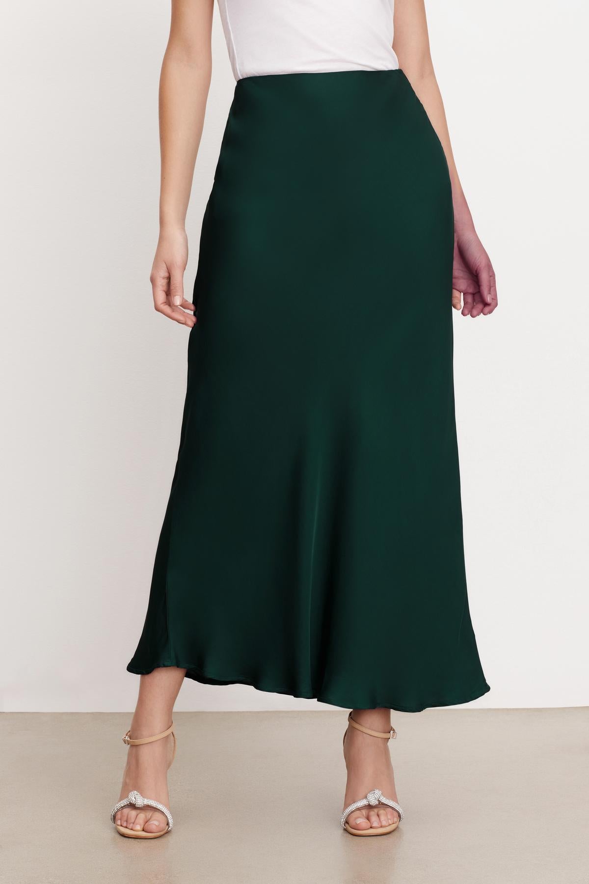   A woman wearing a CADENCE SATIN MAXI SKIRT by Velvet by Graham & Spencer, with a flattering fit and viscose fabric. 