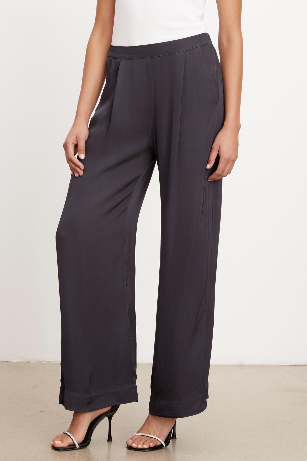   A woman wearing Velvet by Graham & Spencer's LIVI SATIN VISCOSE WIDE LEG PANT and a white top. 