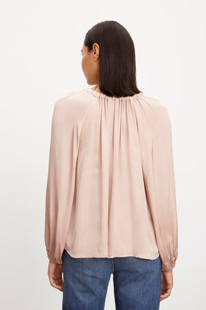 The back view of a woman wearing the NORIA SATIN PEASANT TOP by Velvet by Graham & Spencer.