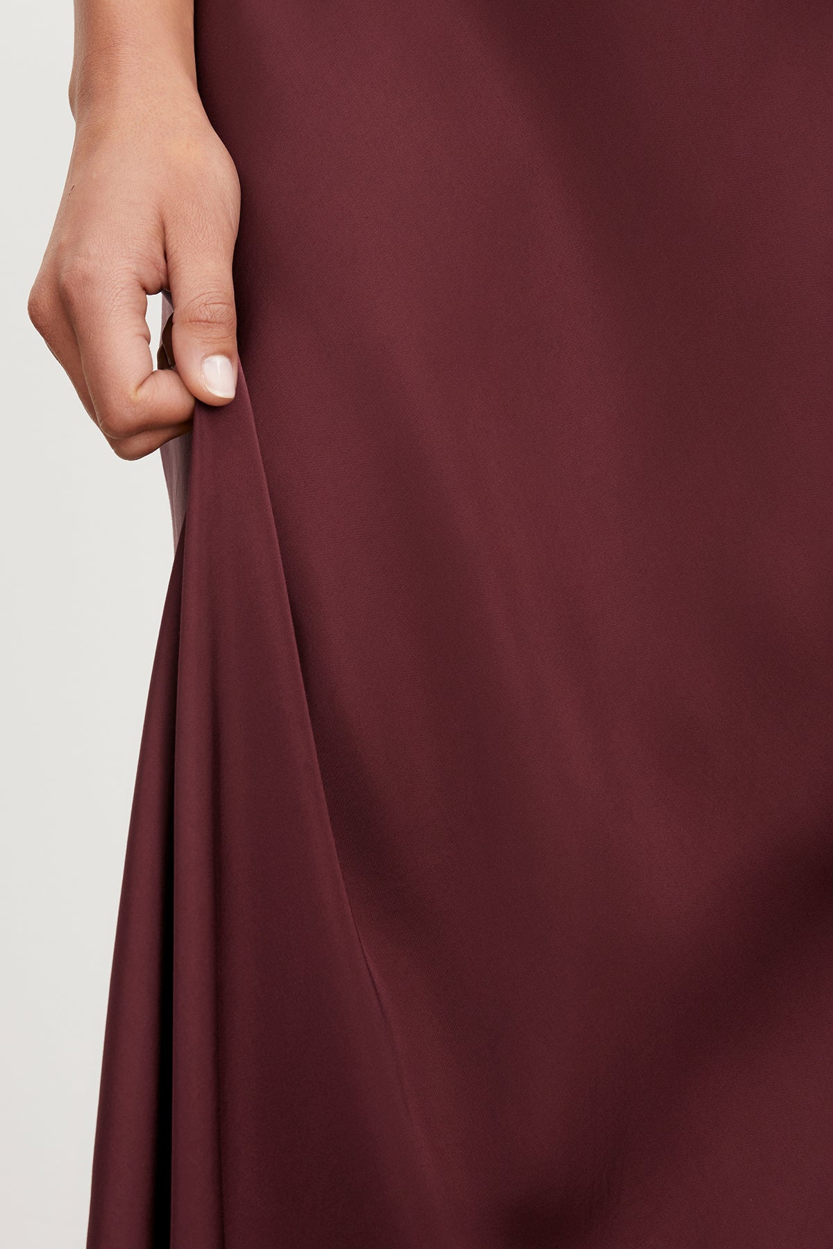   A close up of a woman wearing an adjustable straps Velvet by Graham & Spencer burgundy skirt (POPPY SATIN SLIP DRESS). 