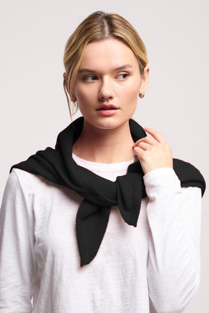 A woman wears a white long-sleeve shirt and has the LARGE TRIANGLE BANDANA BY 40 COLORI from 40 Colori draped over her shoulders, looking to the side against a plain backdrop.