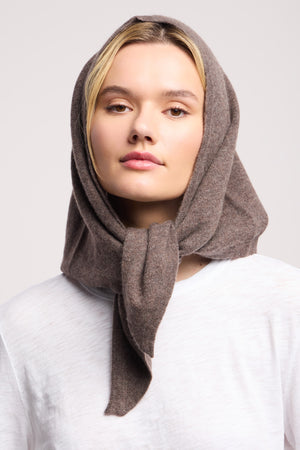 A person in a white shirt and the Large Triangle Bandana by 40 Colori, styled as a head scarf and tied under the chin, models chic Italian accessories from 40 Colori against a simple light backdrop.