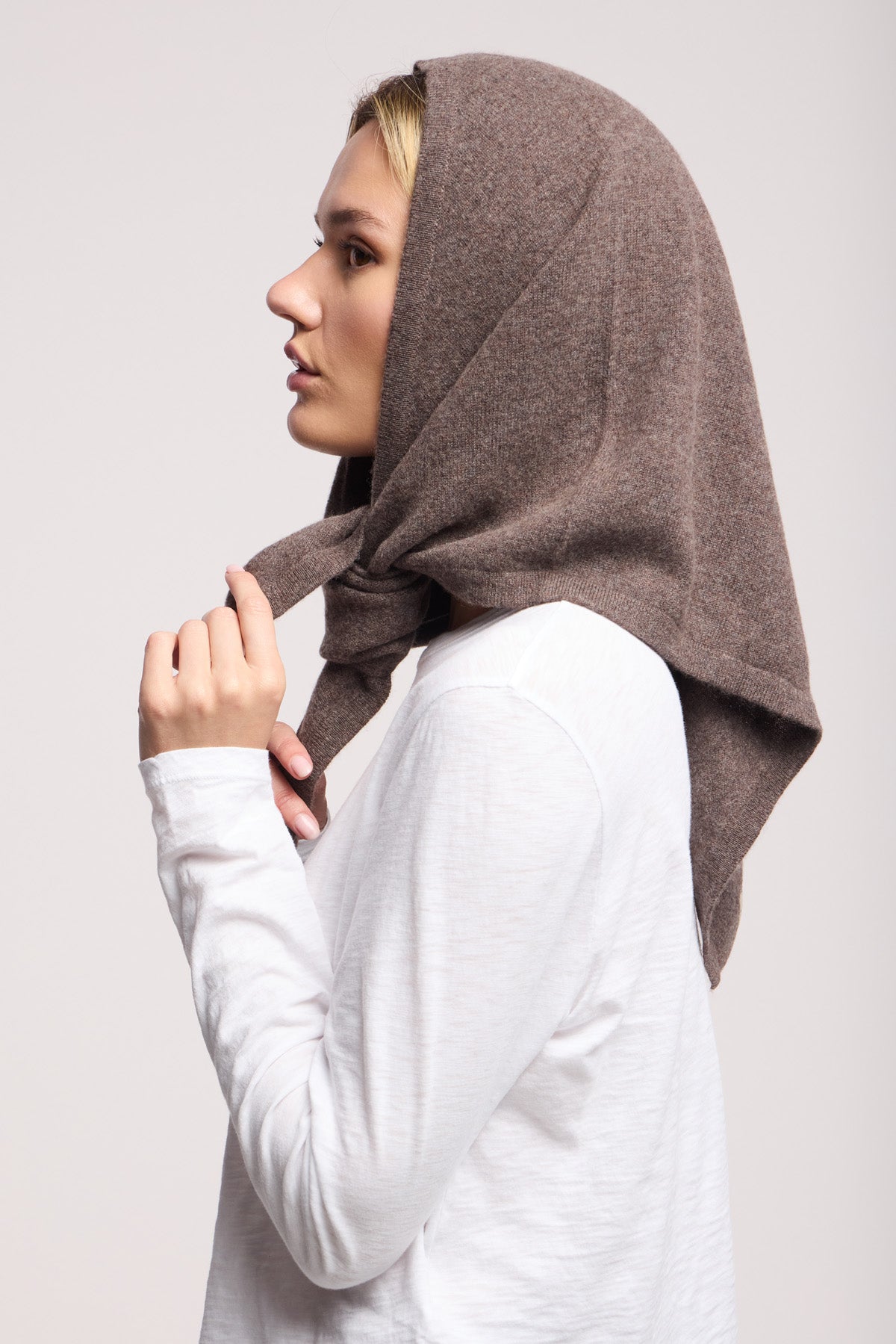 A person in profile wears the LARGE TRIANGLE BANDANA BY 40 COLORI in brown from 40 Colori, styled with a white long-sleeve shirt against a plain light background.