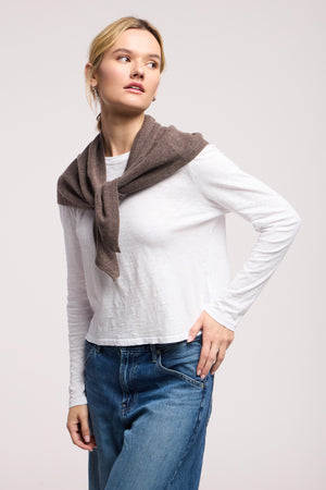 A person wearing a white long-sleeve shirt, blue jeans, a brown sweater over their shoulders, and accessorized with the LARGE TRIANGLE BANDANA BY 40 COLORI stands against a plain background.