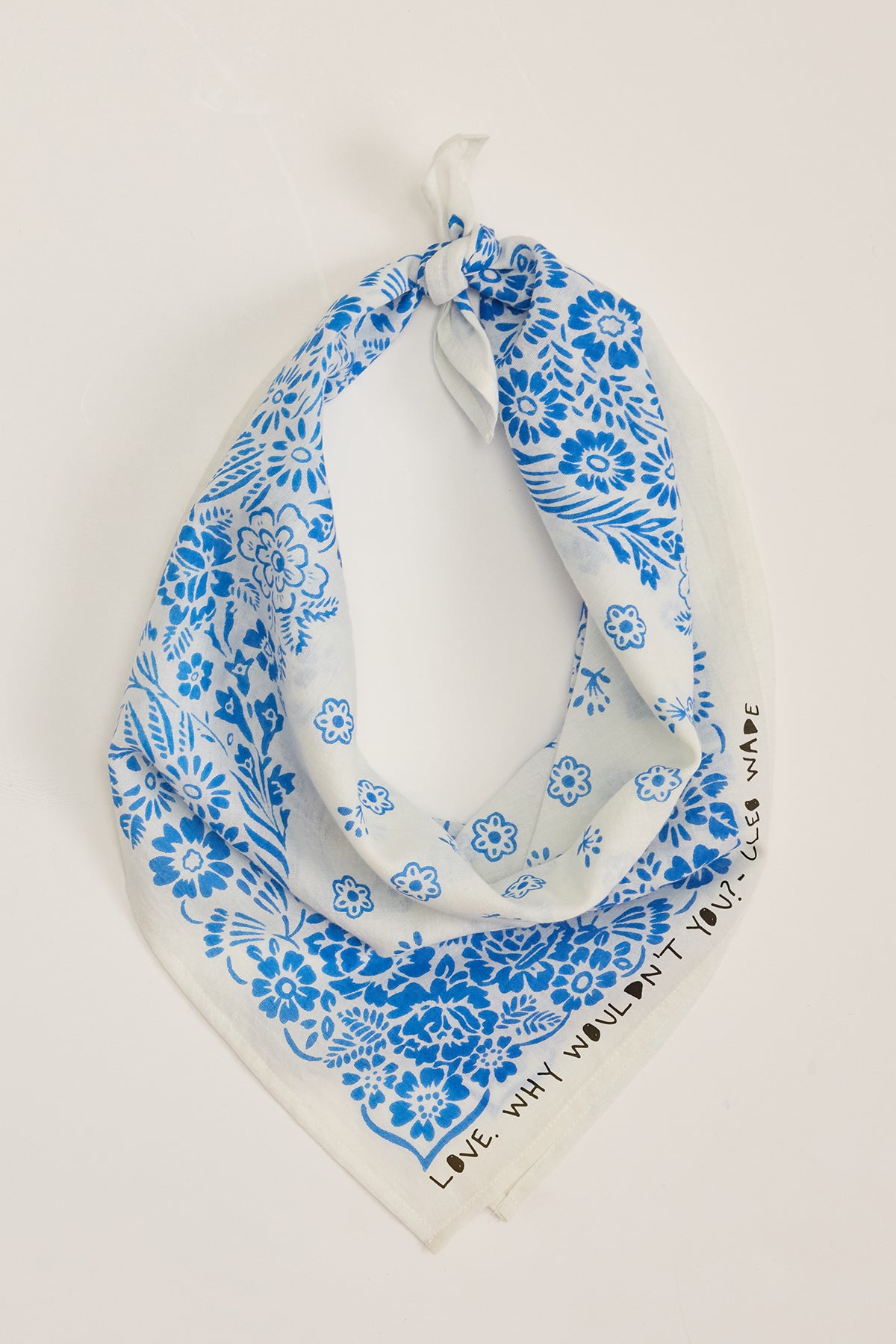 The NOLA SCARF by Velvet by Graham & Spencer is a versatile blue and white bandana crafted from lightweight woven cotton with floral patterns and the inspiring text "LOVE WHY WOULDN'T YOU," echoing Cleo Wade's uplifting words.-38864648896705