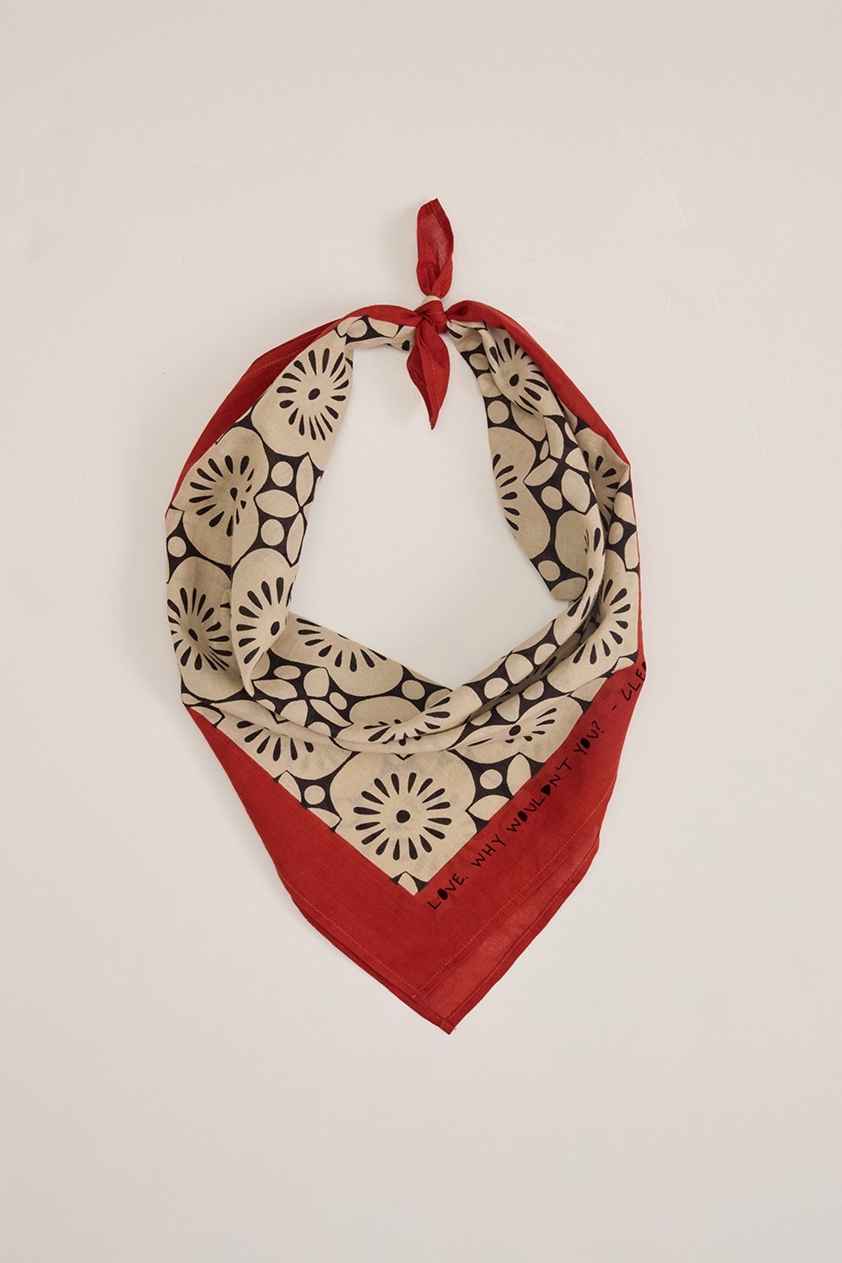 The NOLA SCARF by Velvet by Graham & Spencer is a lightweight cotton bandana with red and beige floral patterns, knotted at the top, adding a perfect Cleo Wade-inspired touch.-38864735764673