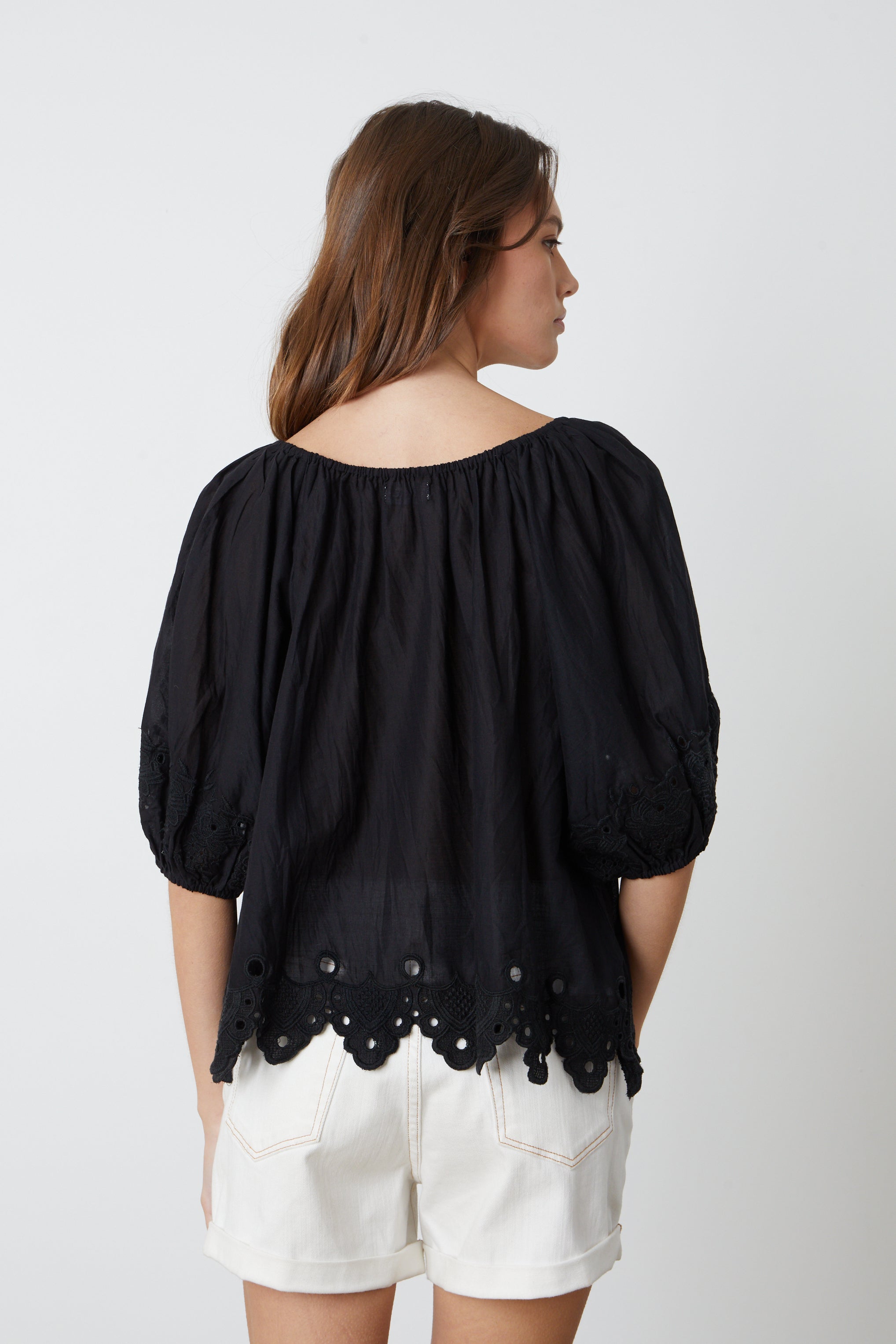   The back view of a woman wearing the Velvet by Graham & Spencer ABIGAIL SCHIFFLI EYELET BLOUSE. 