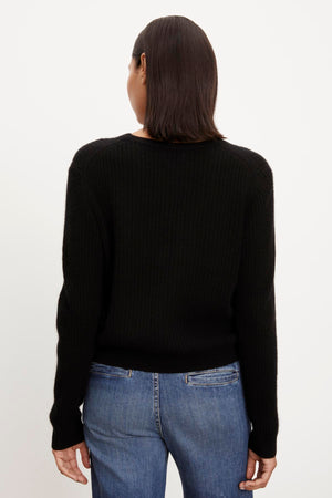 The back view of a person wearing a Velvet by Graham & Spencer CORALIE CASHMERE CARDIGAN and jeans.