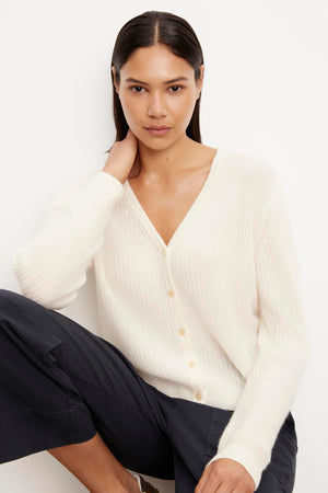 The model is wearing a Coralie Cashmere Cardigan by Velvet by Graham & Spencer and pants.