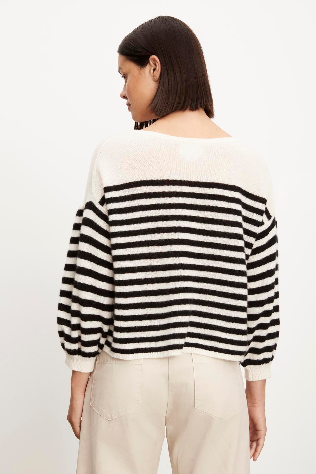   The back view of a woman wearing a Velvet by Graham & Spencer EVA CASHMERE CREW NECK SWEATER. 