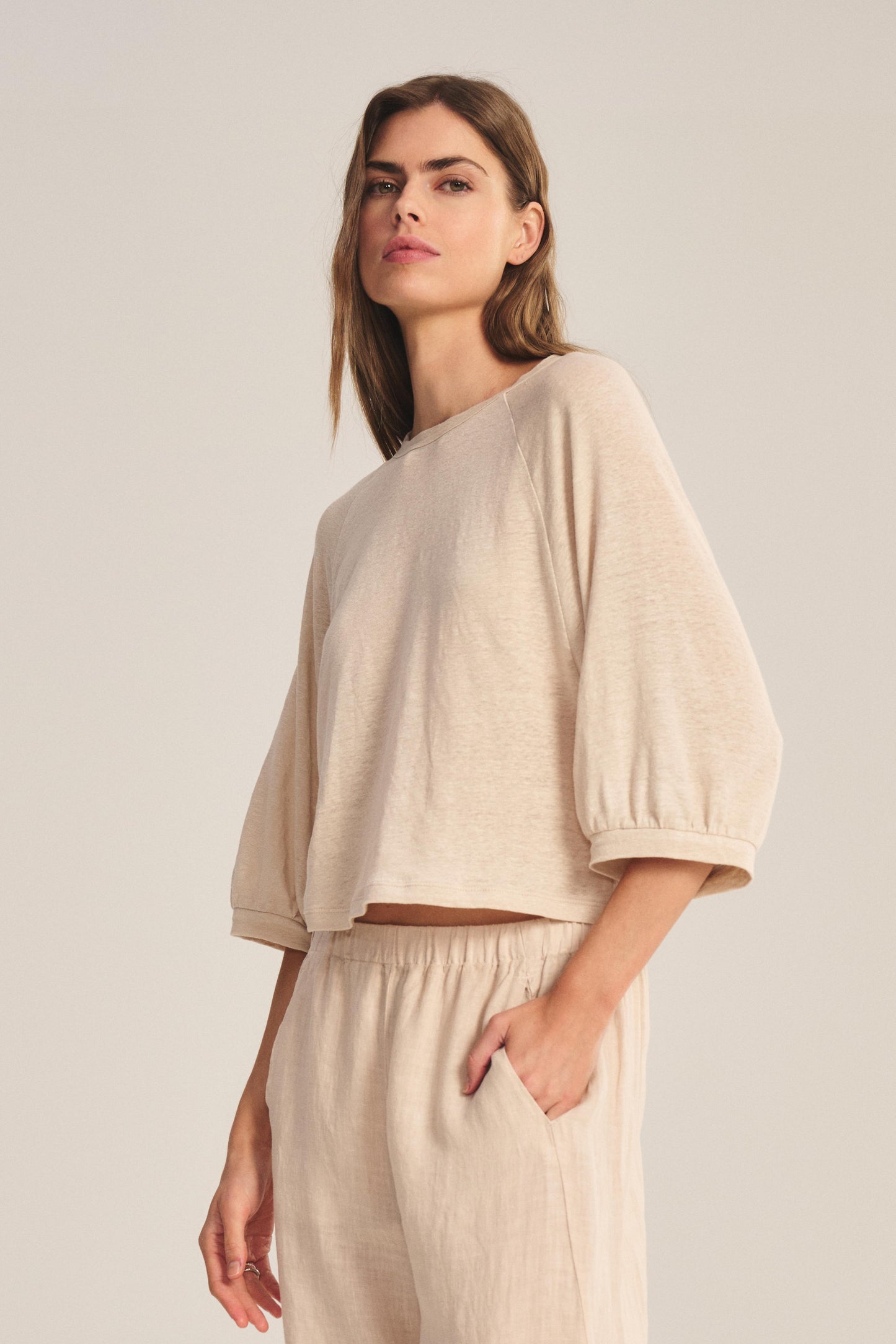 A person wears the SHELLY TEE by Velvet by Graham & Spencer with matching pants, styled loosely and comfortably, one hand in a pocket, standing against a plain background.-41588385874113
