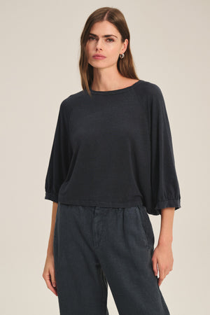 A woman wears the SHELLY TEE by Velvet by Graham & Spencer with matching relaxed pants, standing against a plain light background.
