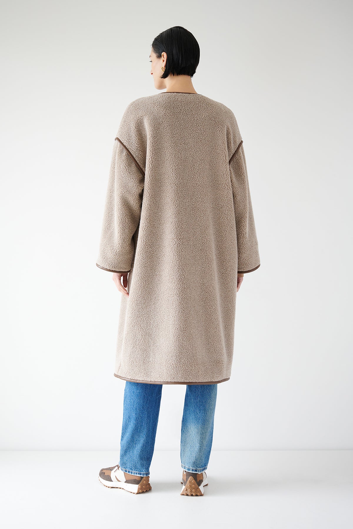 The back view of a woman wearing a Velvet by Jenny Graham Greenwich coat with faux leather trims.-35547408466113