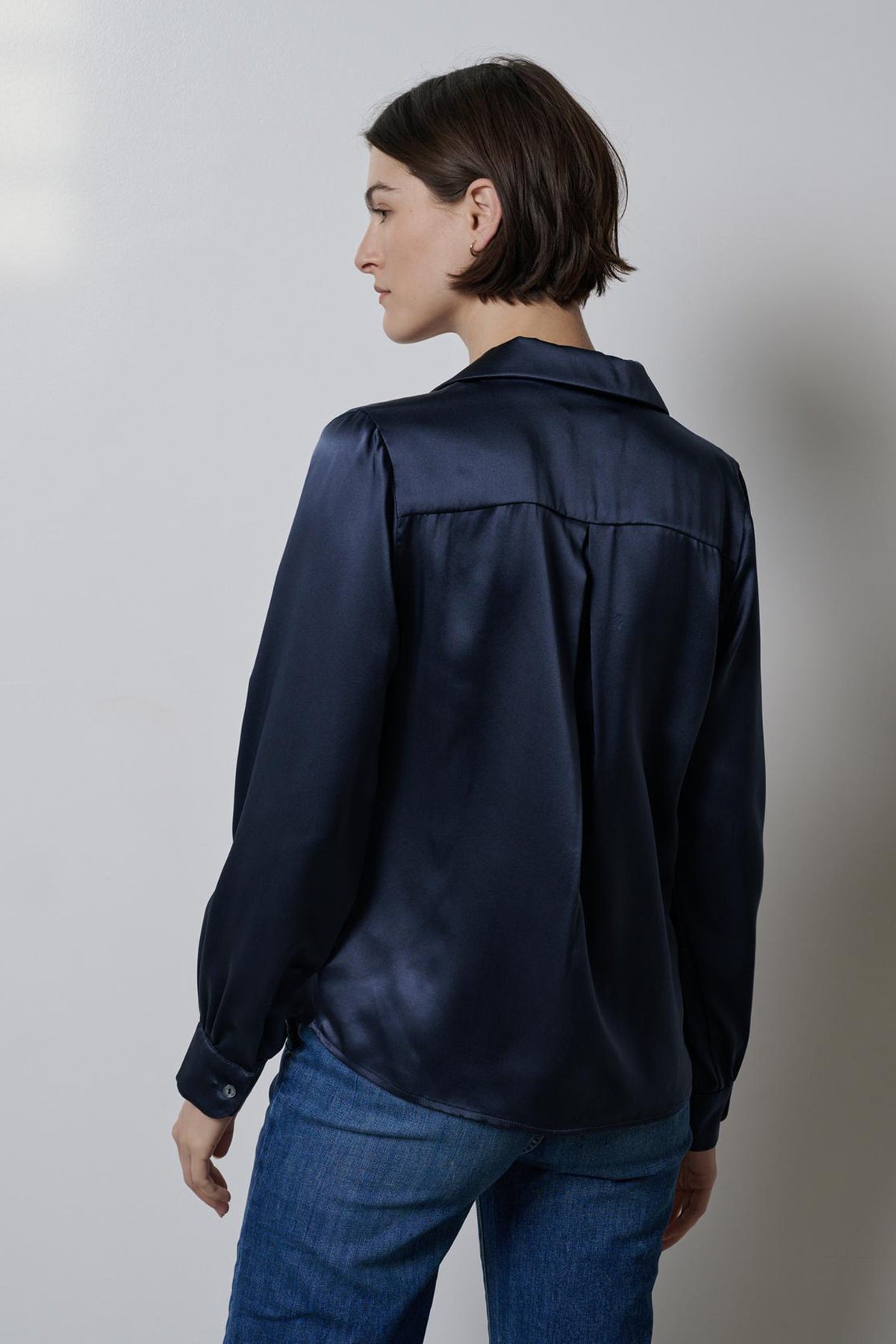 The back view of a timeless woman wearing a Velvet by Jenny Graham navy silk charmeuse SOHO TOP.-35548175106241