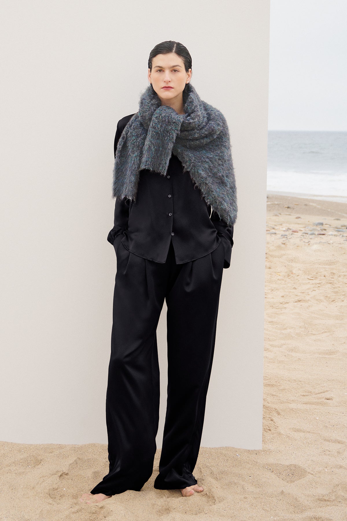 A woman wearing Velvet by Jenny Graham's timeless black pants and a scarf on the beach.-35547961065665