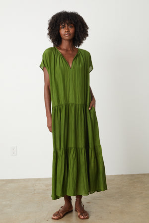 a woman wearing a green ADA TIERED MAXI DRESS by Velvet by Graham & Spencer.