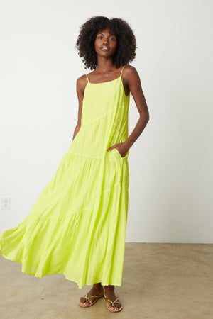 A woman wearing a Velvet by Graham & Spencer BILLIE TIERED MAXI DRESS in neon yellow.