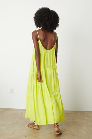 The back view of a woman wearing a Velvet by Graham & Spencer Billie Tiered Maxi Dress in lime green.