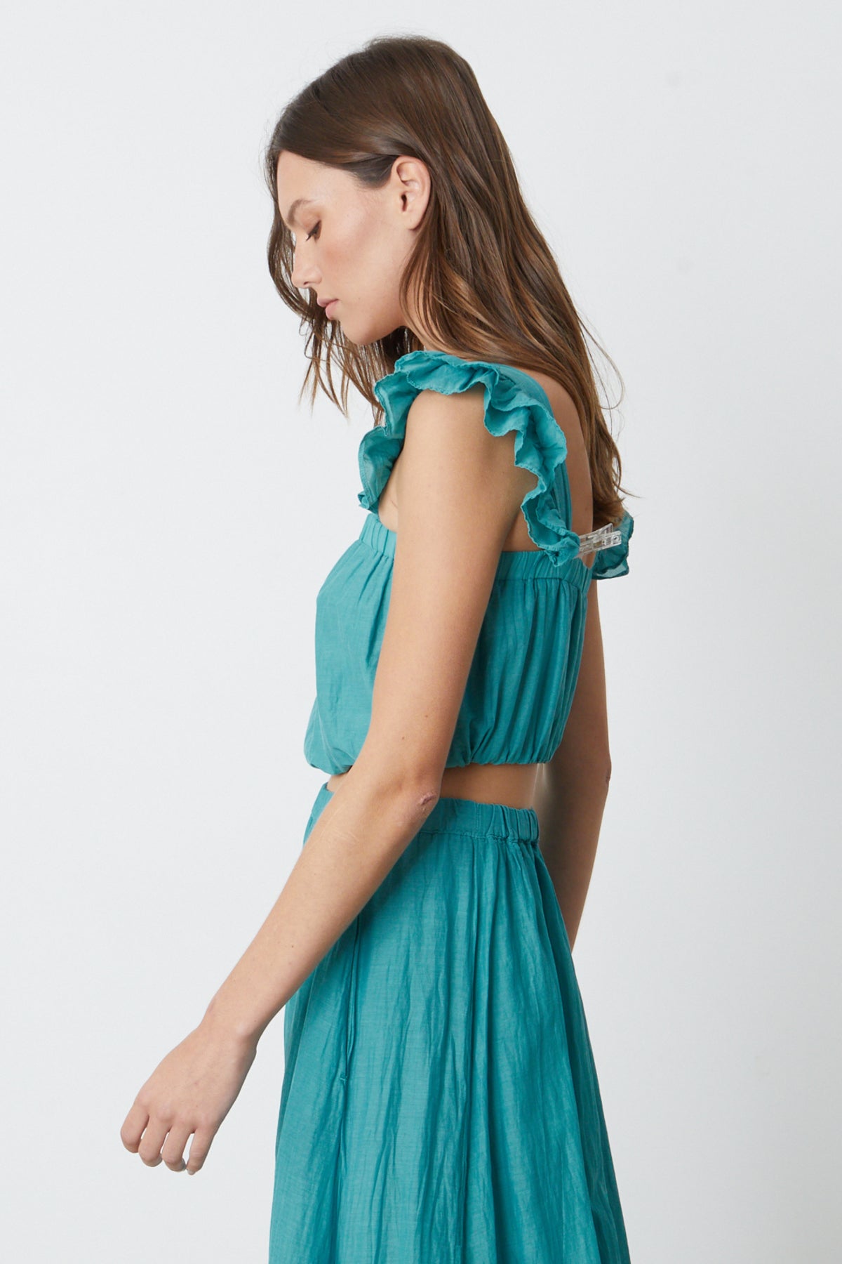   The model is wearing a GRACEN CROPPED TANK TOP by Velvet by Graham & Spencer with ruffled shoulders. 
