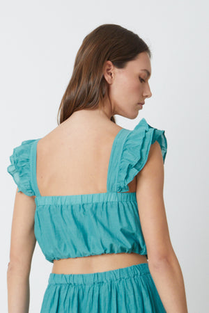 The backview of a person wearing a Velvet by Graham & Spencer GRACEN CROPPED TANK TOP.