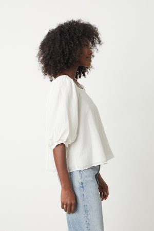 The view of a woman wearing the Velvet by Graham & Spencer JOLENE SILK COTTON TOP and jeans.